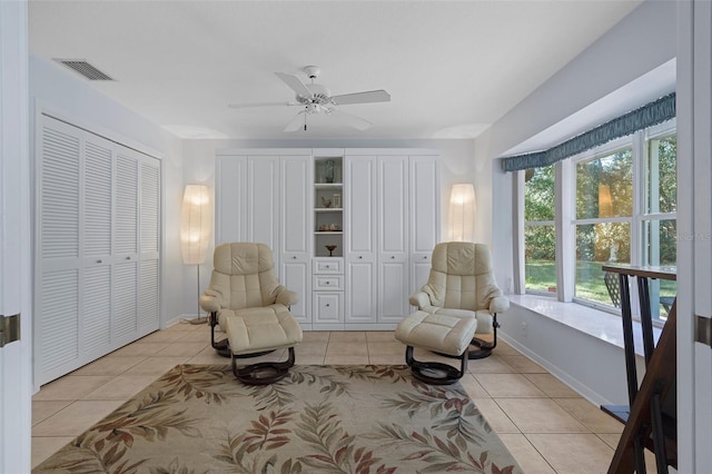 living area featuring light tile patterned floors and ceiling fan