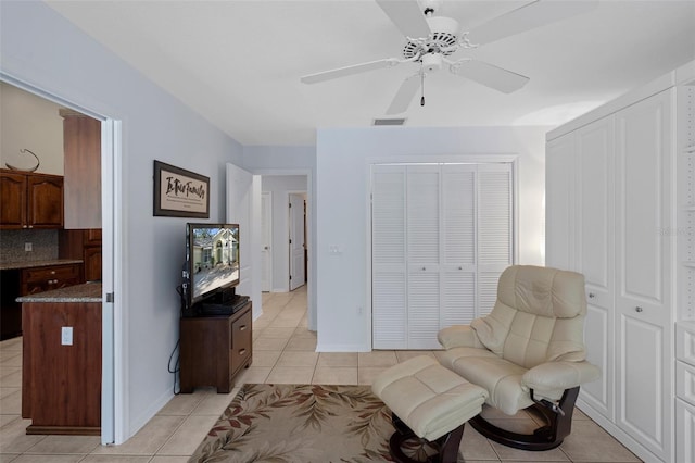 sitting room featuring light tile patterned flooring and ceiling fan