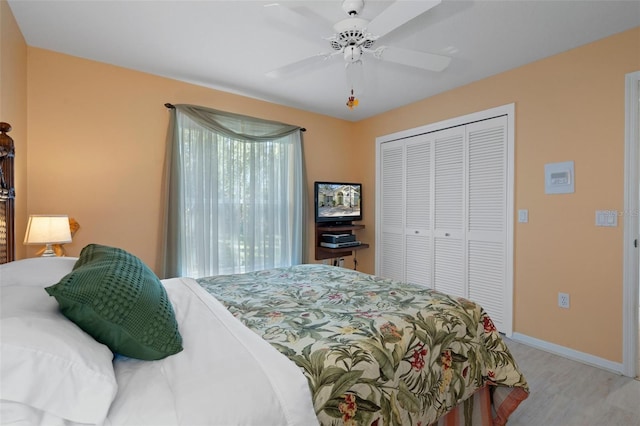 bedroom with light hardwood / wood-style flooring, a closet, and ceiling fan