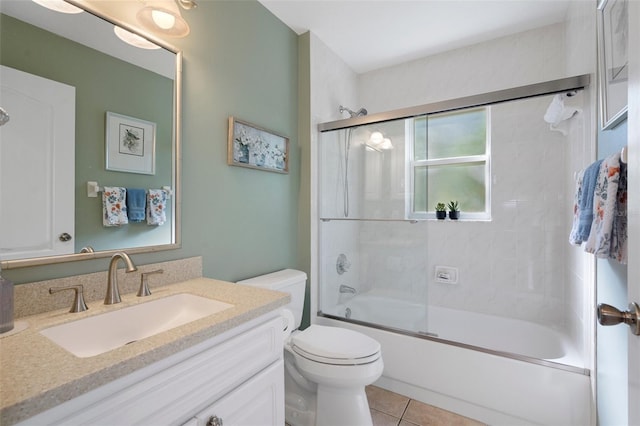 full bathroom with vanity, toilet, tile patterned flooring, and combined bath / shower with glass door