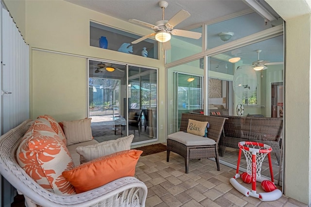 sunroom / solarium featuring ceiling fan