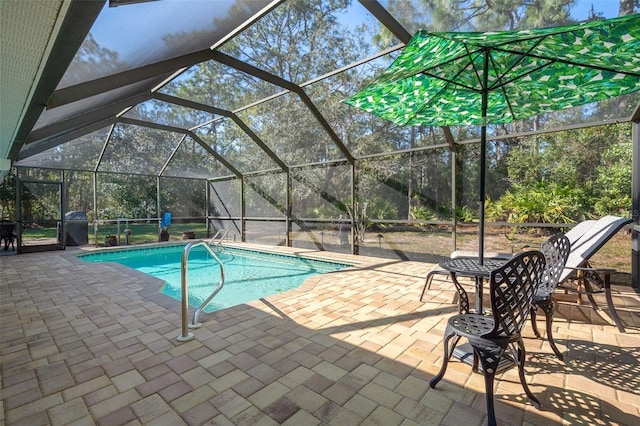 view of swimming pool with a patio area and glass enclosure