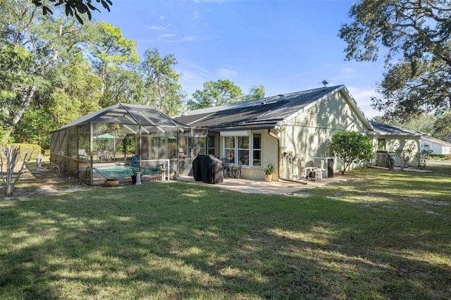 back of house featuring a patio, glass enclosure, and a lawn