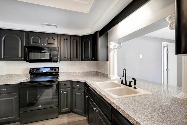 kitchen with ornate columns, sink, decorative backsplash, light hardwood / wood-style floors, and black appliances