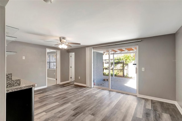 unfurnished living room with ceiling fan and wood-type flooring