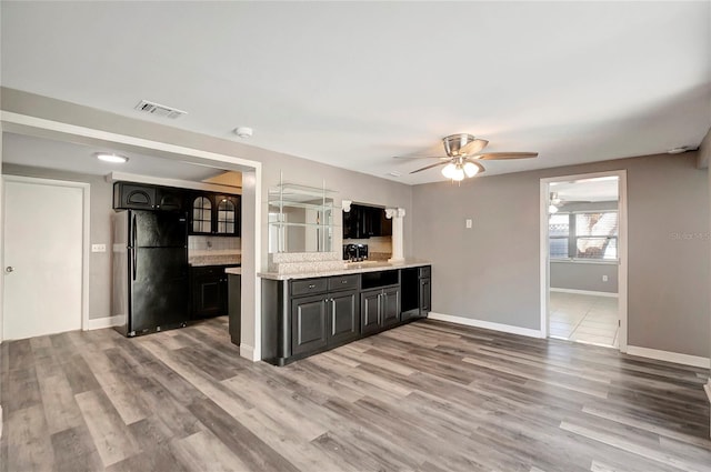 kitchen featuring black fridge, sink, hardwood / wood-style floors, and ceiling fan