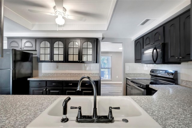 kitchen with a raised ceiling, sink, backsplash, and black appliances