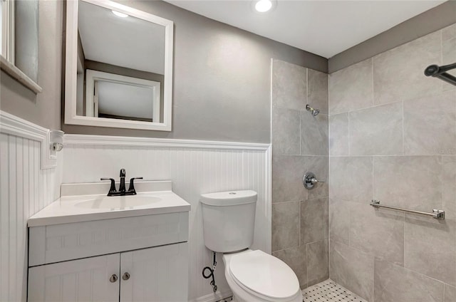 bathroom with vanity, tiled shower, and toilet