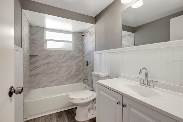 full bathroom with tiled shower / bath, vanity, toilet, and wood-type flooring