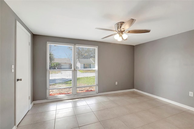 tiled spare room featuring ceiling fan