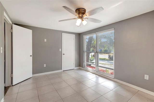 empty room featuring ceiling fan and light tile patterned flooring