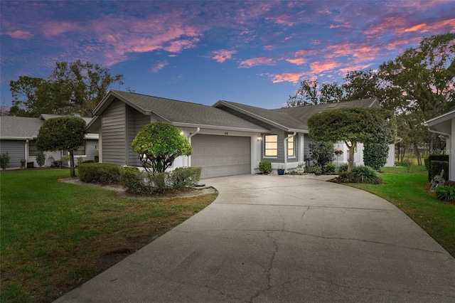 single story home with a garage and a yard