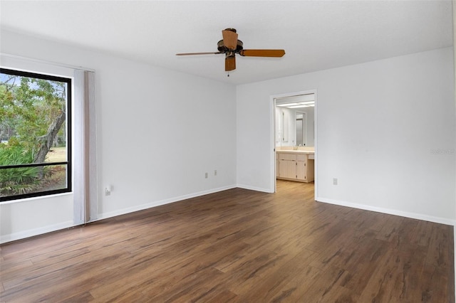 unfurnished room featuring dark wood-type flooring, ceiling fan, and sink