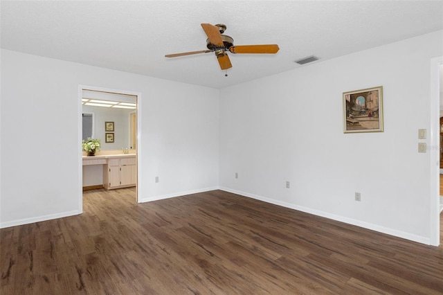 unfurnished bedroom featuring sink, hardwood / wood-style flooring, ceiling fan, ensuite bathroom, and a textured ceiling