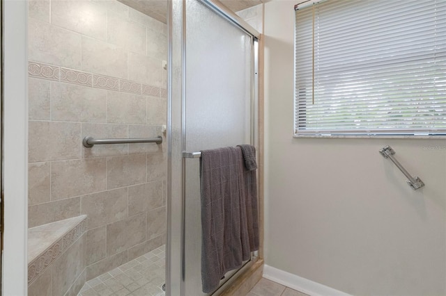 bathroom featuring a shower with shower door and tile patterned flooring