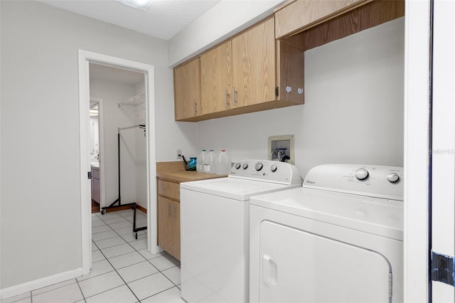 washroom with independent washer and dryer, light tile patterned floors, and cabinets