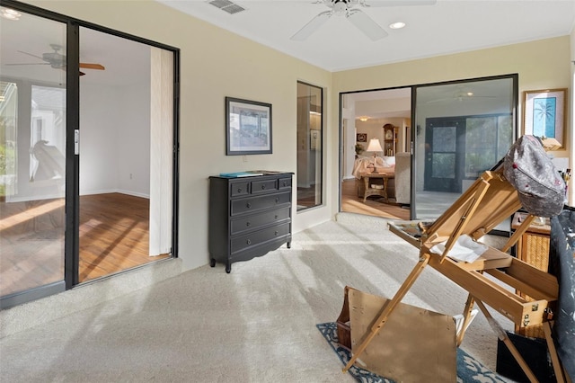 bedroom featuring access to exterior, light colored carpet, and ceiling fan