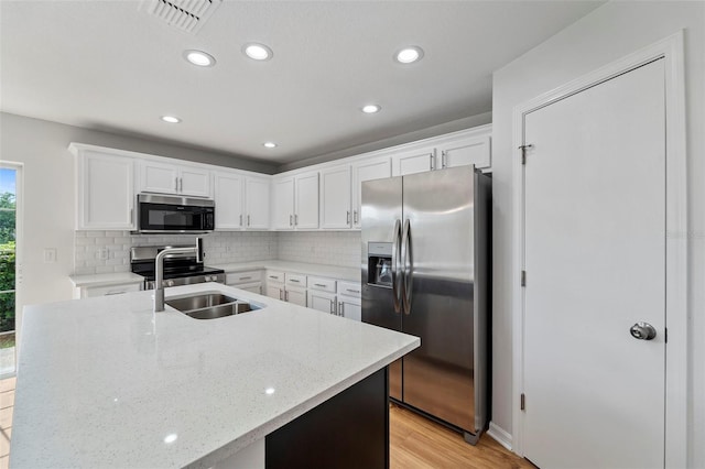 kitchen featuring sink, tasteful backsplash, appliances with stainless steel finishes, light stone countertops, and white cabinets