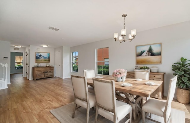 dining area featuring an inviting chandelier and light hardwood / wood-style flooring