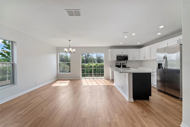 kitchen featuring appliances with stainless steel finishes, decorative light fixtures, white cabinetry, sink, and decorative backsplash