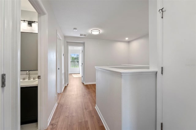 hall featuring sink and light wood-type flooring