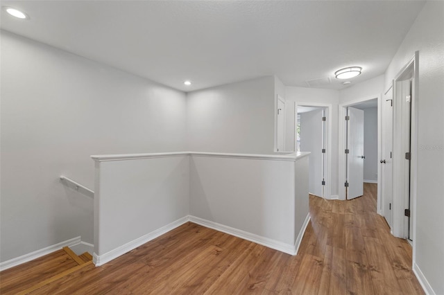 corridor with hardwood / wood-style flooring