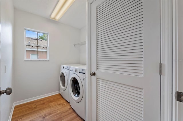 laundry room with washer and clothes dryer and light hardwood / wood-style flooring