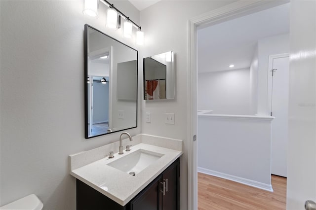 bathroom with vanity, toilet, and hardwood / wood-style floors