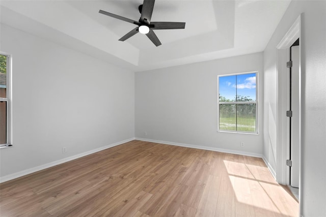 interior space featuring ceiling fan, a raised ceiling, and light hardwood / wood-style floors