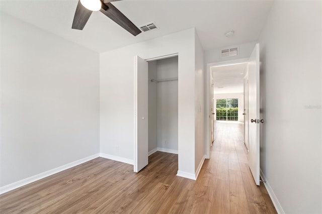 unfurnished bedroom with light hardwood / wood-style floors, a closet, and ceiling fan