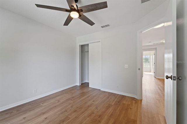 unfurnished bedroom with light hardwood / wood-style floors, a closet, and ceiling fan