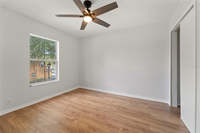 empty room with ceiling fan and light hardwood / wood-style flooring