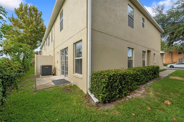 view of home's exterior featuring a lawn and central air condition unit