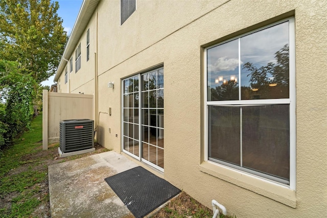 view of side of property featuring central AC unit and a patio area