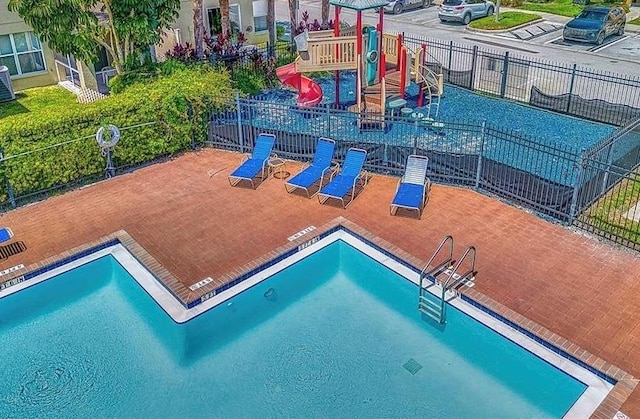 view of swimming pool featuring a playground