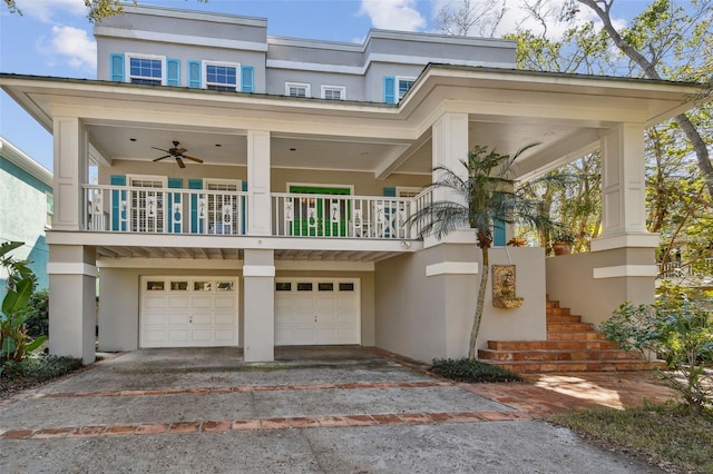 view of front facade with stairs, driveway, an attached garage, and stucco siding