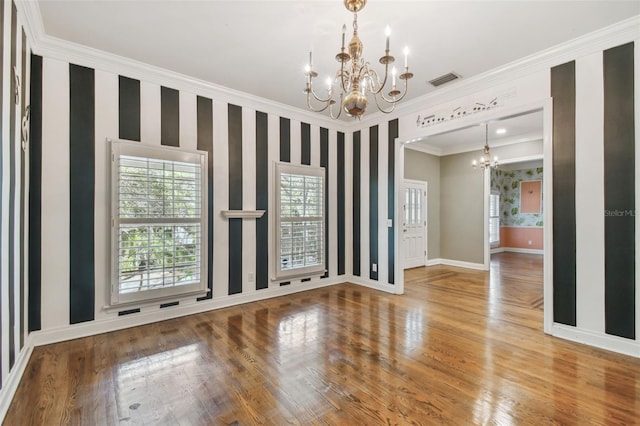 unfurnished room featuring a chandelier, baseboards, wood finished floors, and wallpapered walls