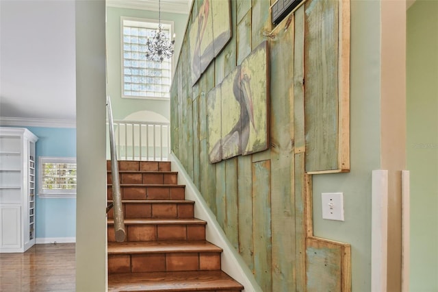 stairs featuring a notable chandelier, baseboards, and crown molding