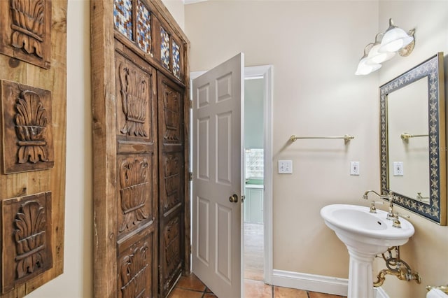 bathroom with baseboards and tile patterned floors