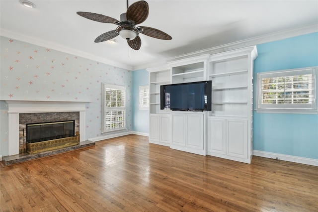 unfurnished living room with baseboards, ornamental molding, and wood finished floors