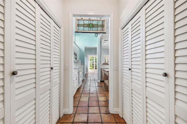 hall with stone tile flooring and baseboards