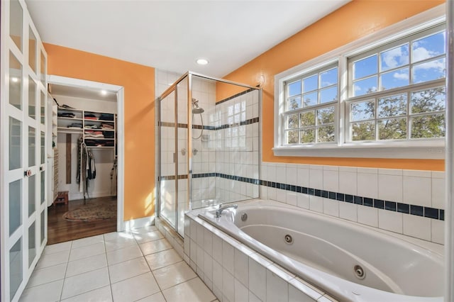 bathroom featuring recessed lighting, a spacious closet, a jetted tub, tile patterned floors, and a stall shower