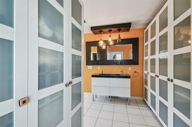 bathroom with tile patterned flooring, a sink, and double vanity