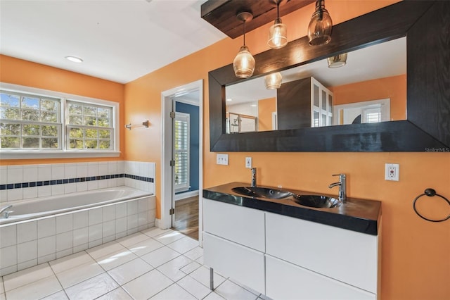 full bathroom featuring tile patterned flooring, a garden tub, and vanity