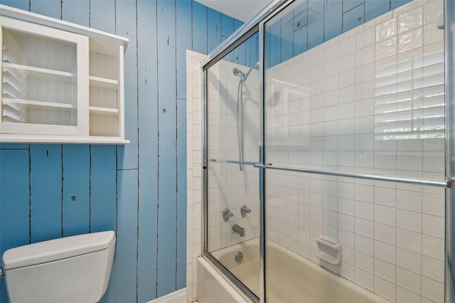 bathroom with enclosed tub / shower combo and toilet