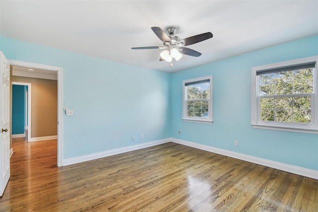 empty room featuring wood finished floors, a ceiling fan, and baseboards