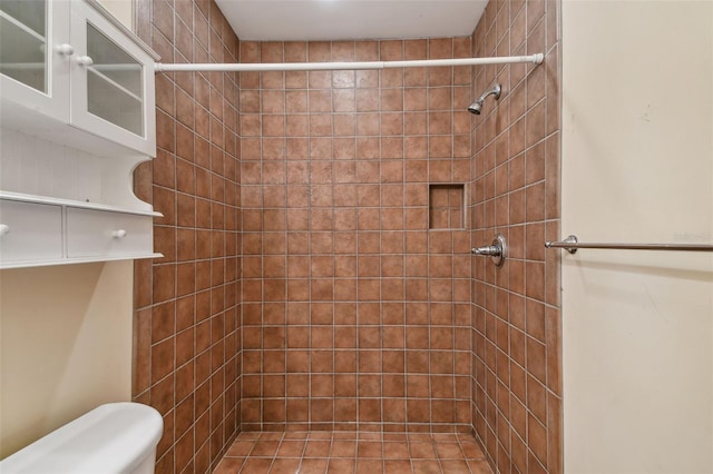 full bathroom featuring toilet and a tile shower