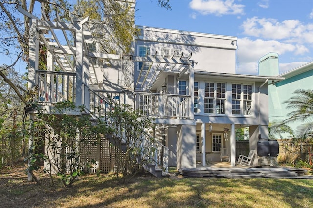 back of property featuring a patio, stairs, a lawn, and stucco siding