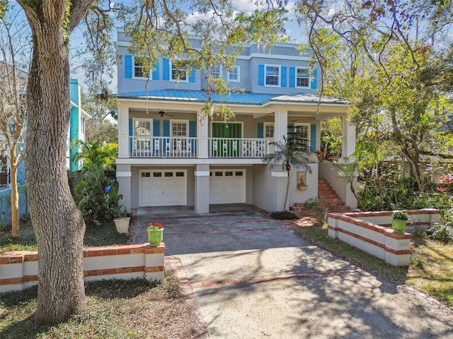 view of front of house featuring metal roof, aphalt driveway, a garage, stairway, and stucco siding