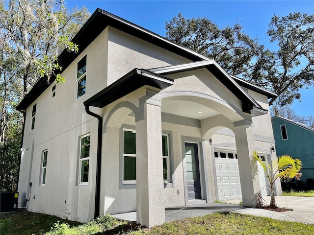 view of front of house with central AC unit and a garage